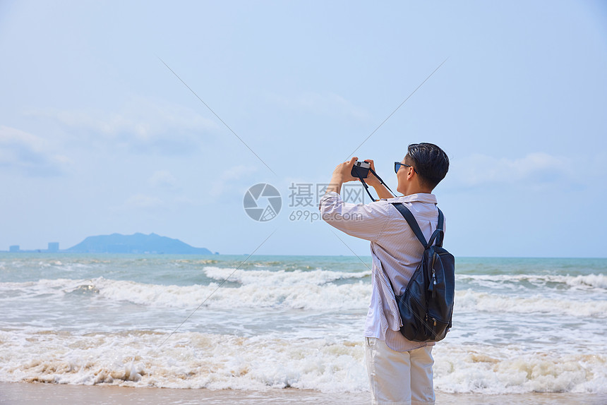 年轻男士海边旅游拍照图片