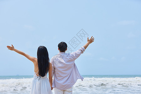 年轻情侣拥抱大海背影图片