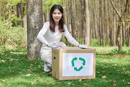 女性抱着纸箱回收垃圾图片