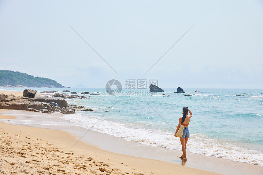 年轻美女海边旅行背影图片