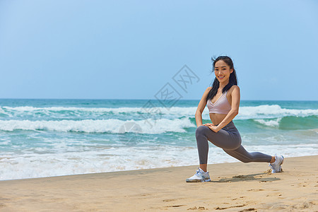 年轻美女海边运动拉伸图片