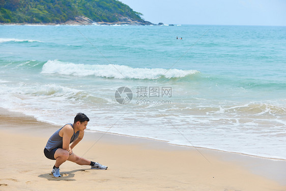 男青年海边运动拉伸图片