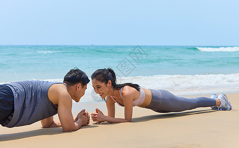 年轻情侣海边做平板支撑图片