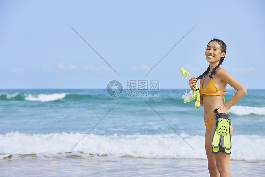 比基尼美女在海边拿着潜水装备图片