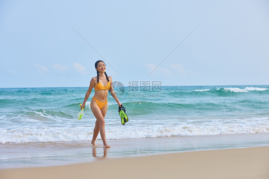 比基尼美女在海边拿着潜水装备图片