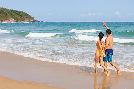 年轻情侣海边牵手散步图片