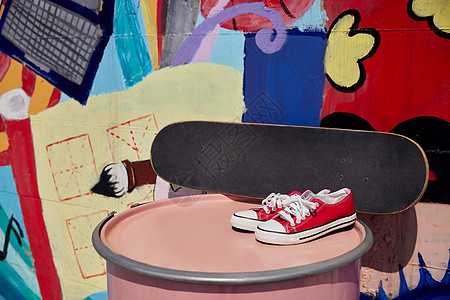 街头涂鸦墙边的滑板帆布鞋背景图片