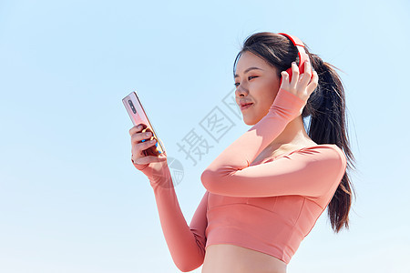 青年女性跑步运动戴耳机休息背景图片