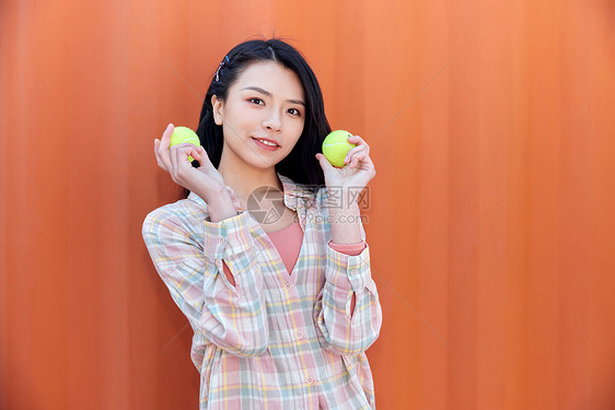 青年活力女性手拿网球图片