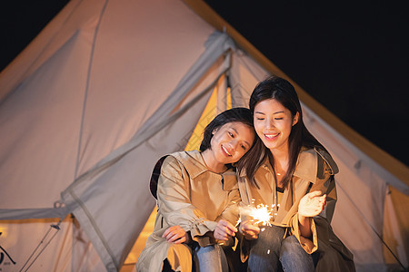 夜晚帐篷闺蜜两人在帐篷外放烟花背景
