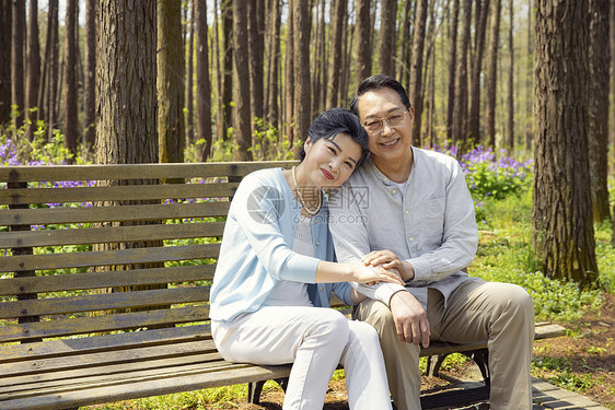 坐在公园长椅上休息的老年夫妇图片