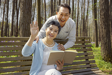 户外阅读看书的老年夫妇打招呼图片