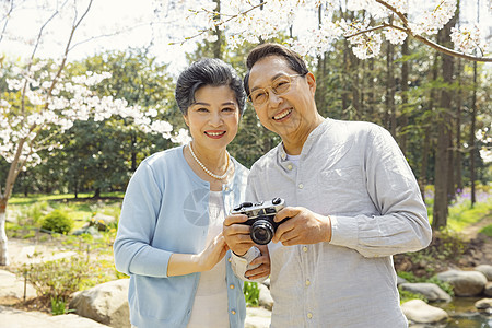 踏青的老年夫妇公园拍照图片