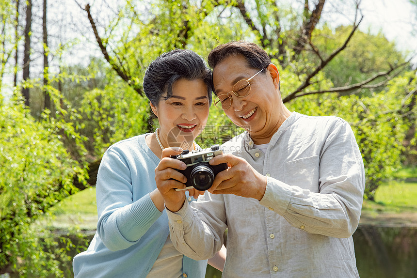 踏青的老年夫妇公园拍照图片