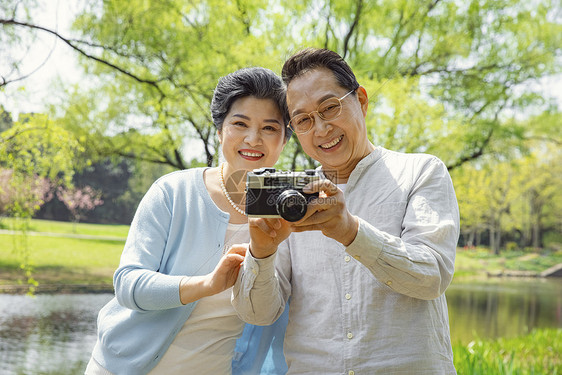 踏青的老年夫妇公园拍照图片