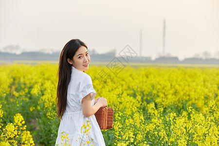 在油菜花田散步的年轻女性图片