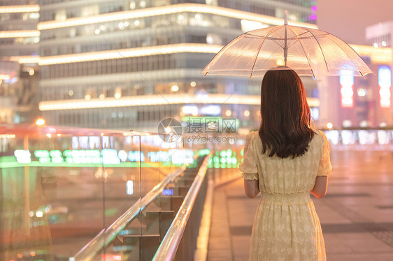 下雨天走在城市里的女性背影图片