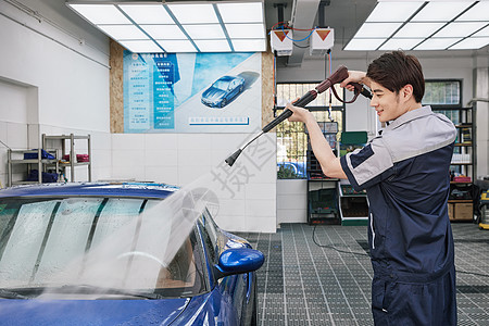 清洁工人拿高压水枪冲洗汽车图片