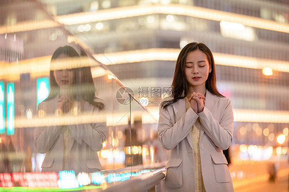城市里祈祷的女性图片