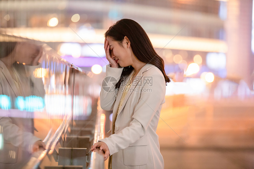 城市里捂脸伤心难过的女性图片