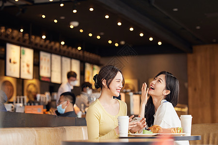 在咖啡店开心大笑的年轻女性高清图片