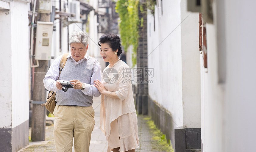 老年夫妻古镇巷子游玩拍照图片