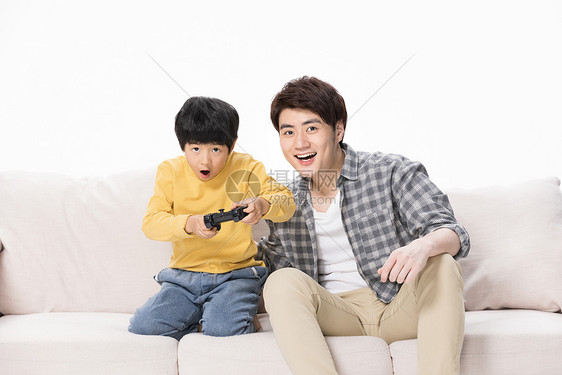 父子居家沙发上玩电子游戏图片