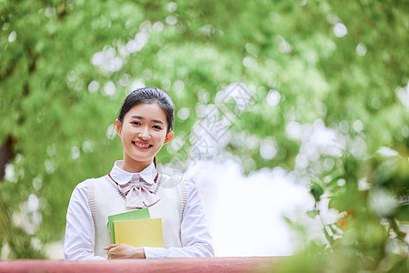 户外抱着书的学生图片