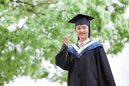 大学毕业季带着学位帽的女生手举毕业证书庆祝毕业背景
