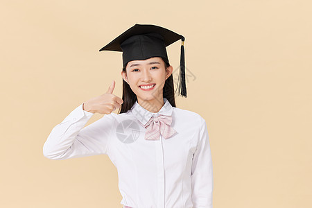 带着学位帽的女生点赞毕业证高清图片素材