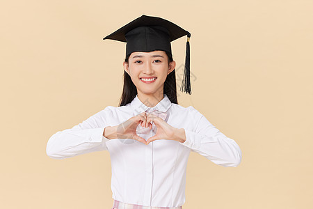 带着学位帽的女生手举毕业证书庆祝毕业同学高清图片素材