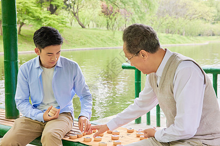 老年父子公园湖边下象棋图片