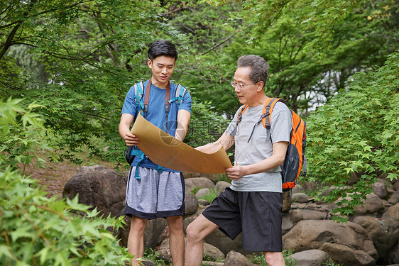 中年父子公园徒步看地图图片