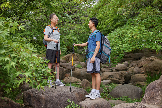 中年父子拿登山仗徒步郊游图片