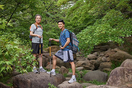 中年父子拿登山仗徒步郊游图片