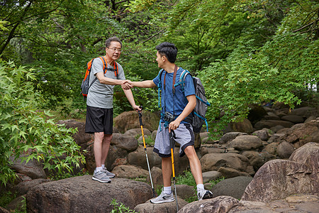 中年父子拿登山仗徒步郊游图片