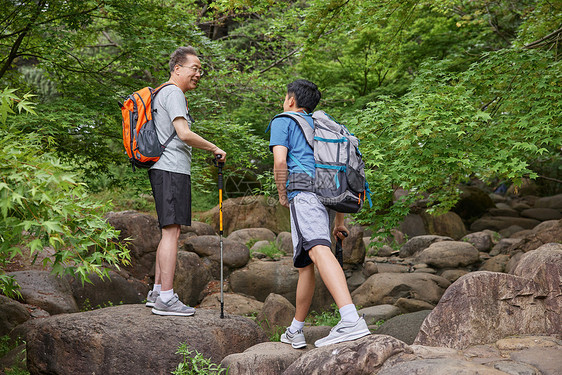 中年父子拿登山仗徒步郊游图片