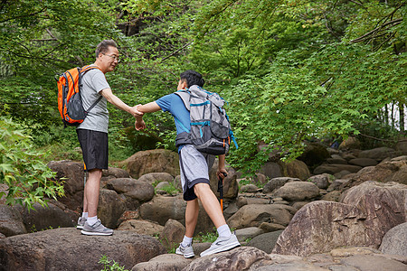 中年父子拿登山仗徒步郊游图片