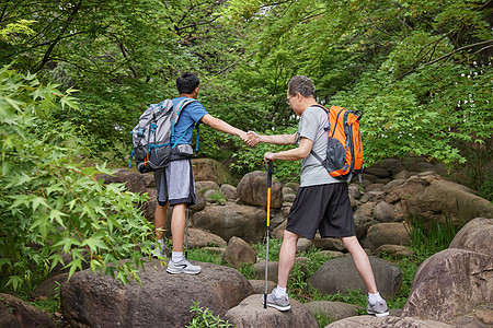 中年父子拿登山仗徒步郊游图片