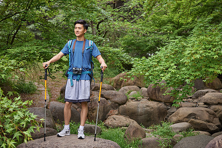 青年男性拿登山杖徒步图片