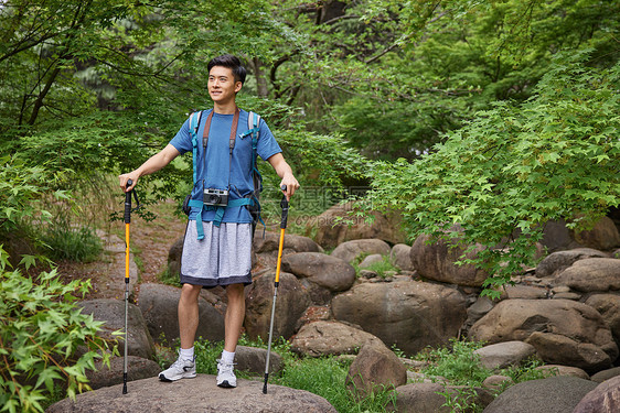 青年男性拿登山杖徒步图片