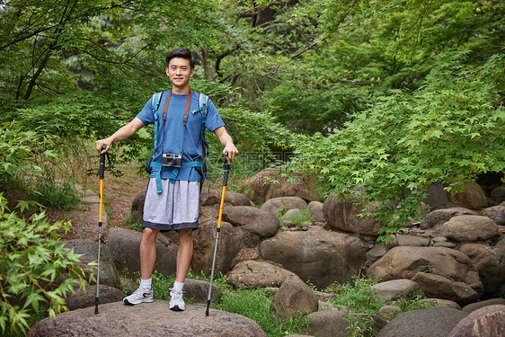 青年男性拿登山杖徒步图片