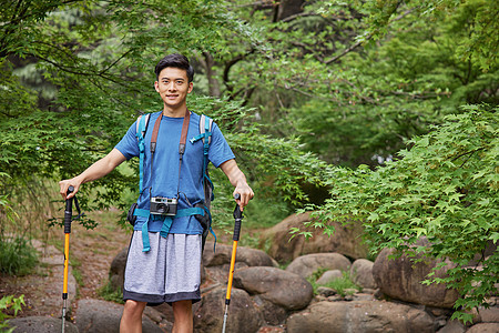 青年男性拿登山杖徒步图片