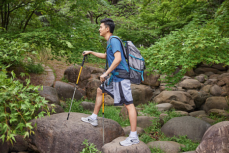 青年男性拿登山杖徒步图片