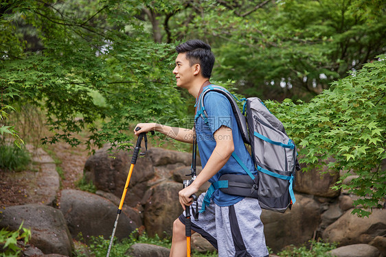 青年男性拿登山杖徒步图片