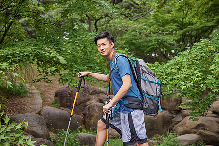 青年男性拿登山杖徒步图片