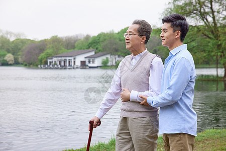 中年父子公园湖边散步图片
