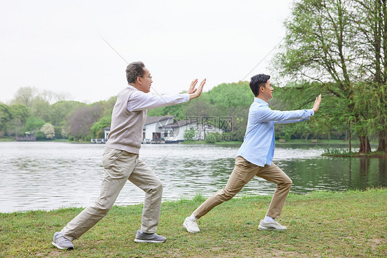 中年父子公园湖边打太极拳图片