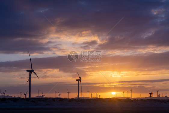 夕阳下的风力发电机剪影图片