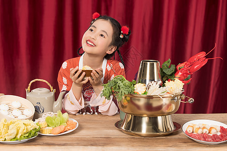 双手捧着饭碗餐桌前的小女孩图片